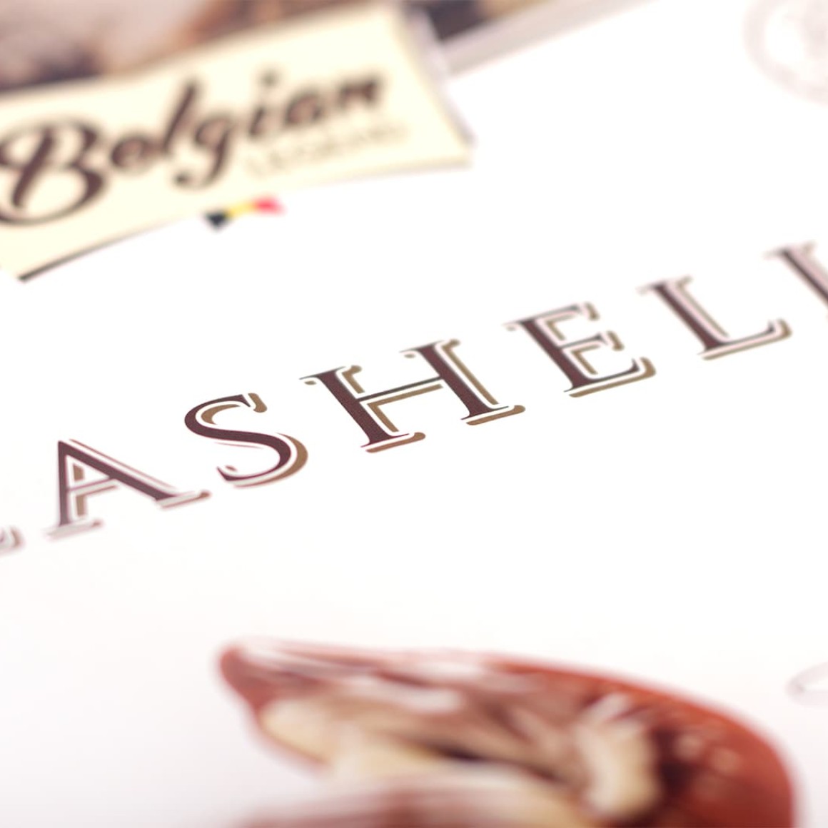 Embossed Seashells logo close-up on Belgian Legend chocolate packaging